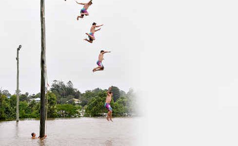 A daredevil jumps from the top of a lightpole into the flood waters below yesterday. A daredevil jumps from the top of a lightpole into the flood waters below yesterday.